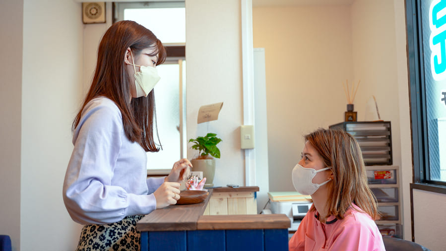 写真:受付で女性二人が向き合っている